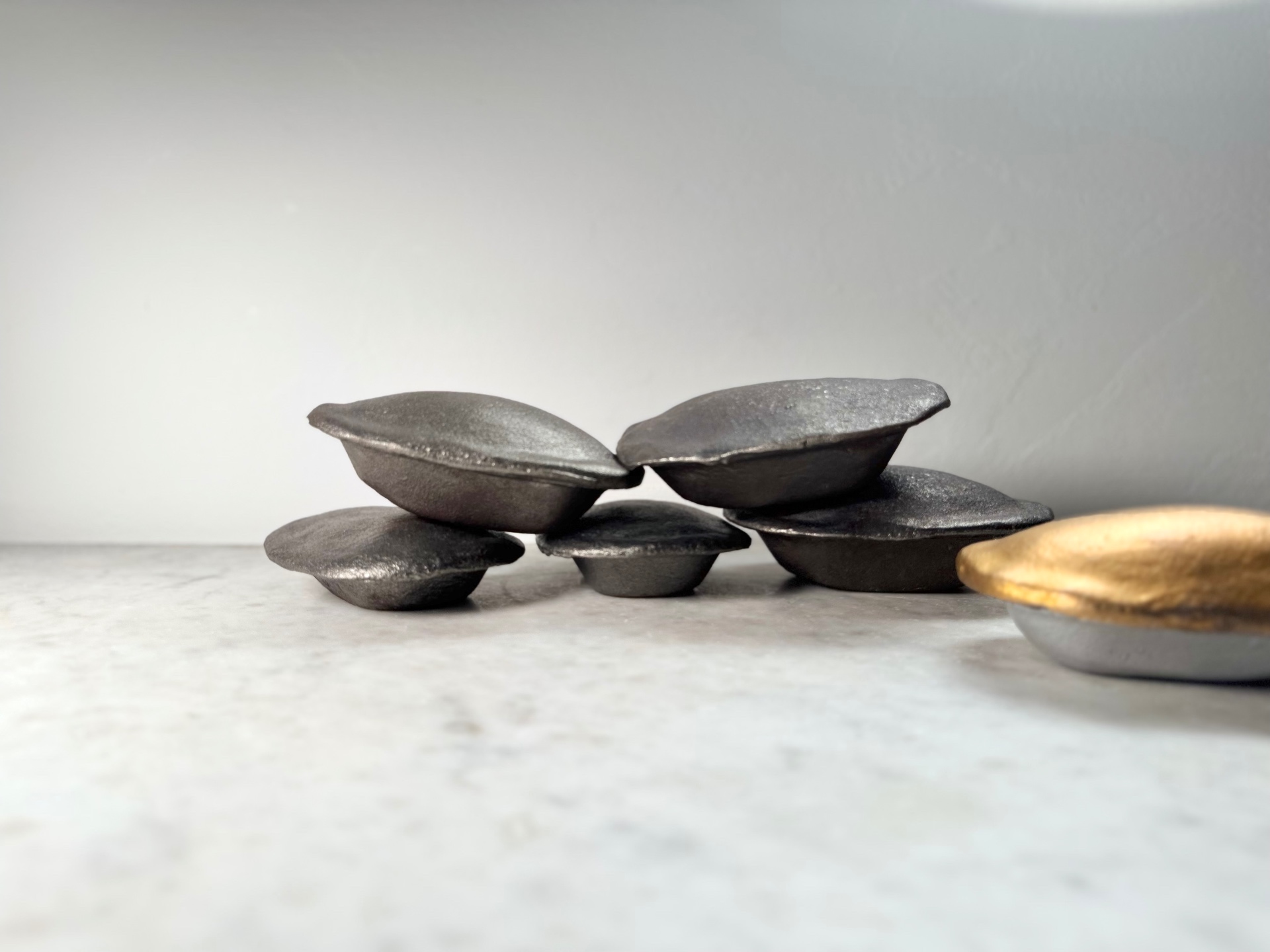 Cast iron pies arranged with a gold pie to the side