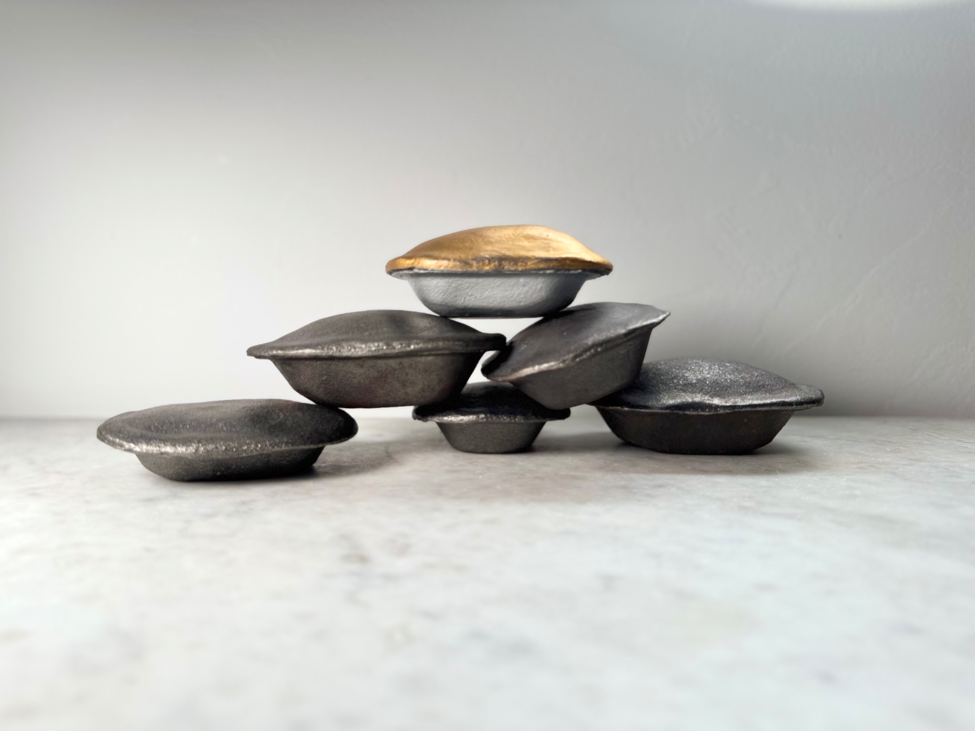 Stack of cast iron pies with a gold-topped piece