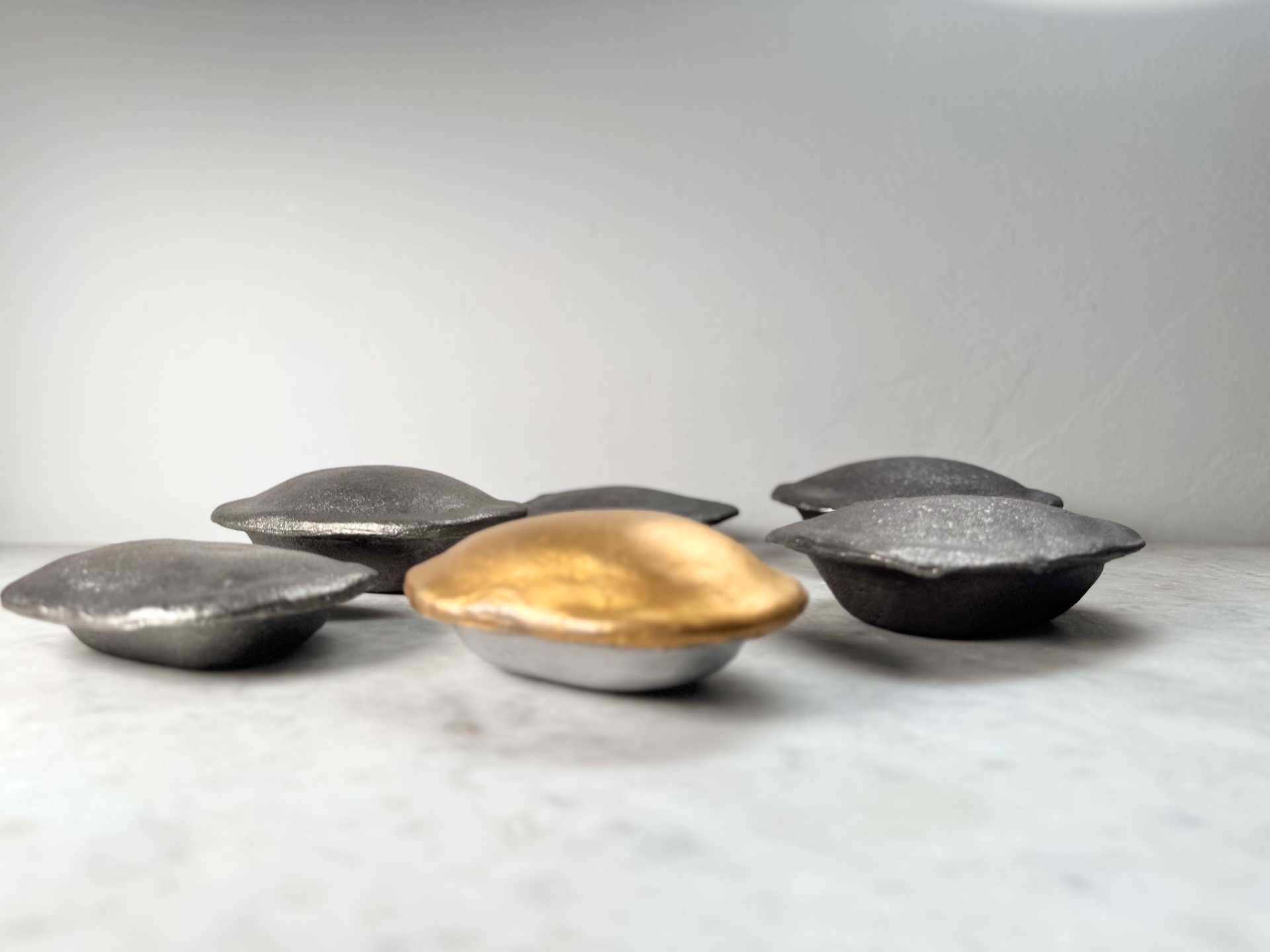 Cast iron pies with a gold and silver piece at centre